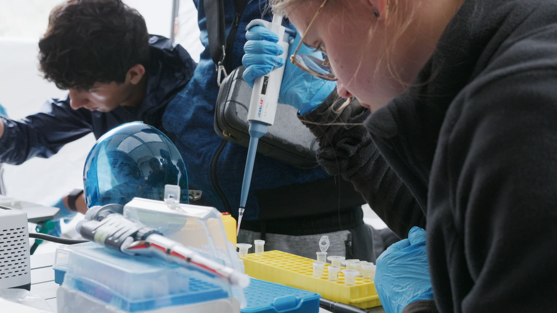 Zwei Personen führen im Laborzelt des Basislagers eine genetische Analyse durch. - Chamrousse - © Léo Previtali Zwei Personen führen im Laborzelt des Basislagers eine genetische Analyse durch. - Chamrousse